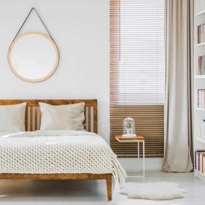 Wooden venetian blind with beige curtain in bedroom