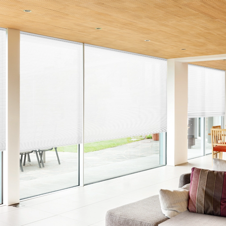 Honeycomb Light filter blinds in sunny living space with large windows and sliding doors